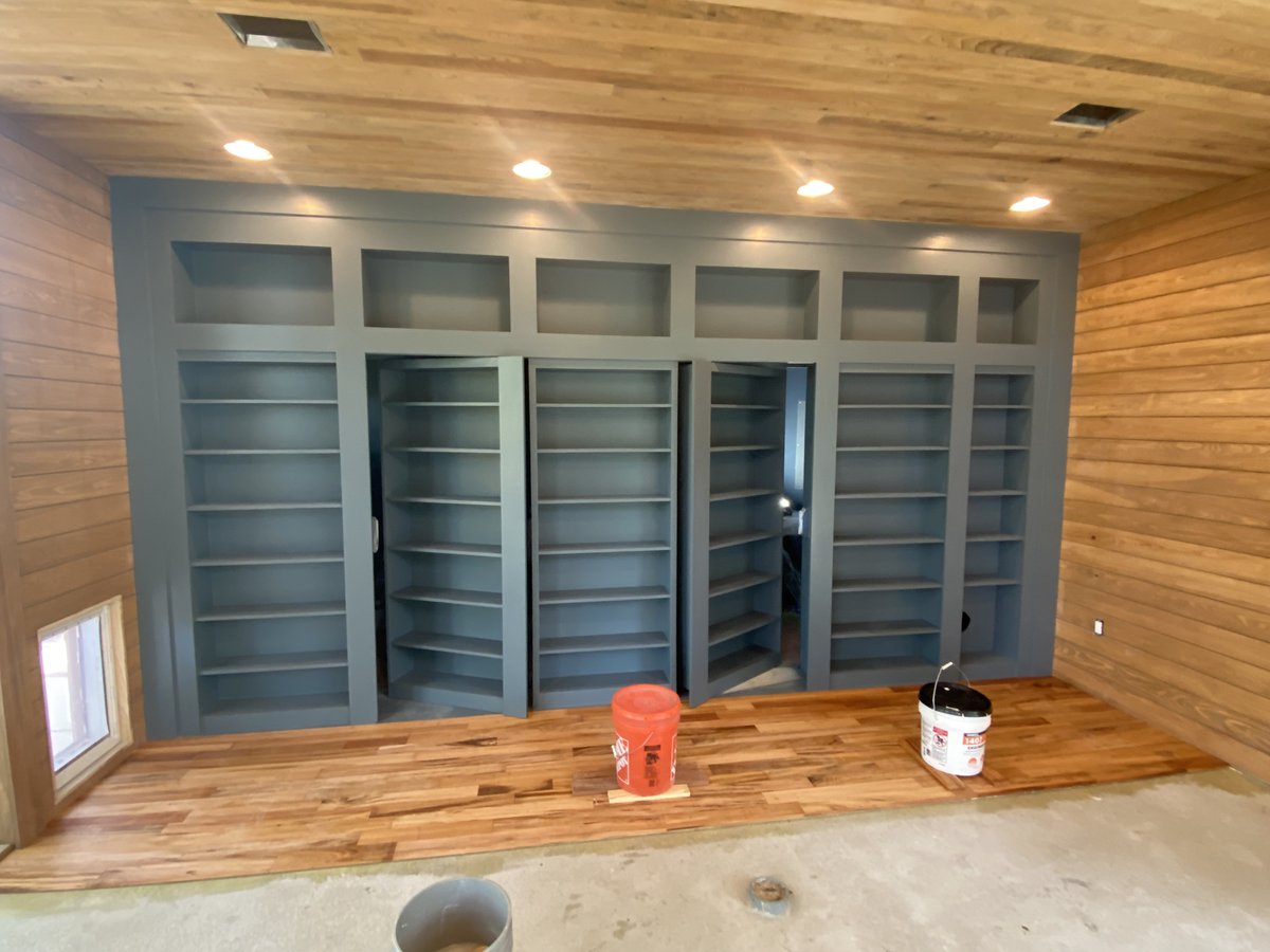Full-wall built-in bookshelves with hidden doors