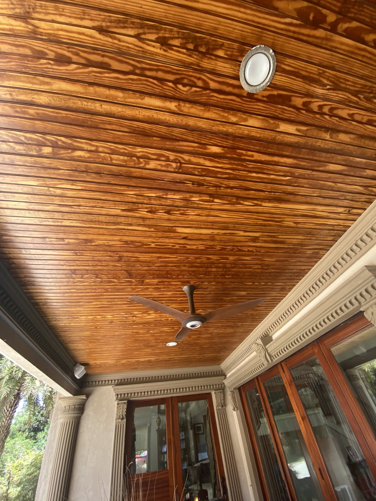 Stained wood porch ceiling with crown molding detail