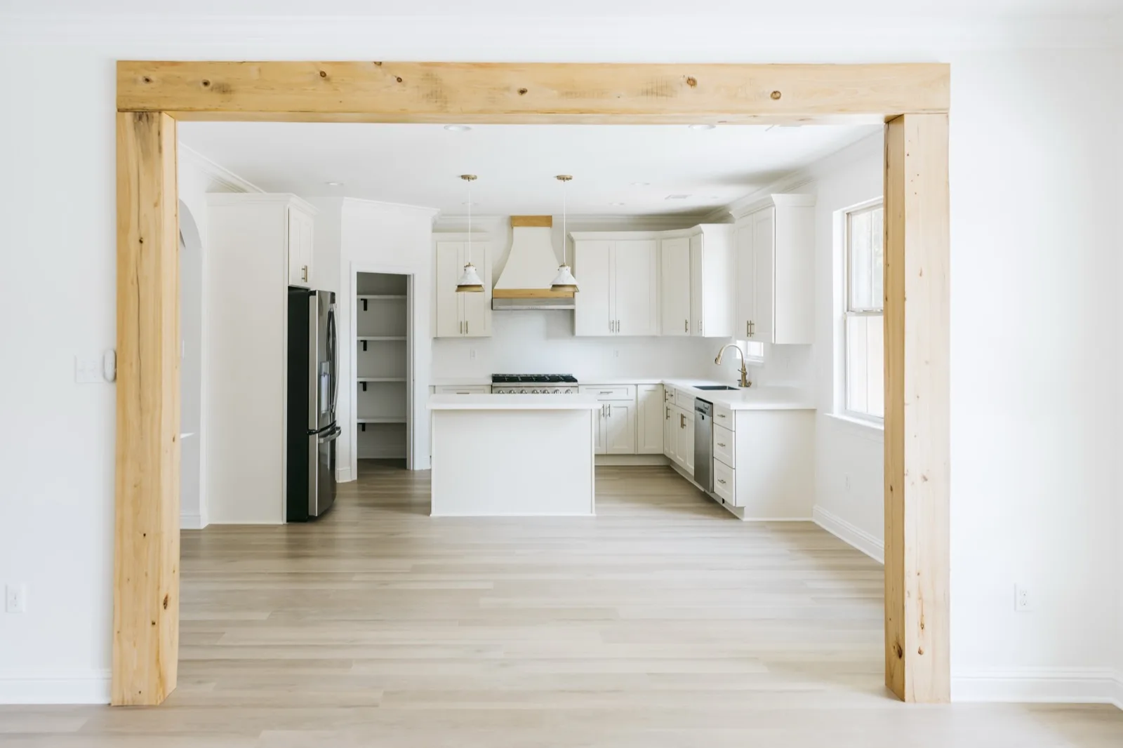 Kitchen viewed through exposed cypress beam and post frame
