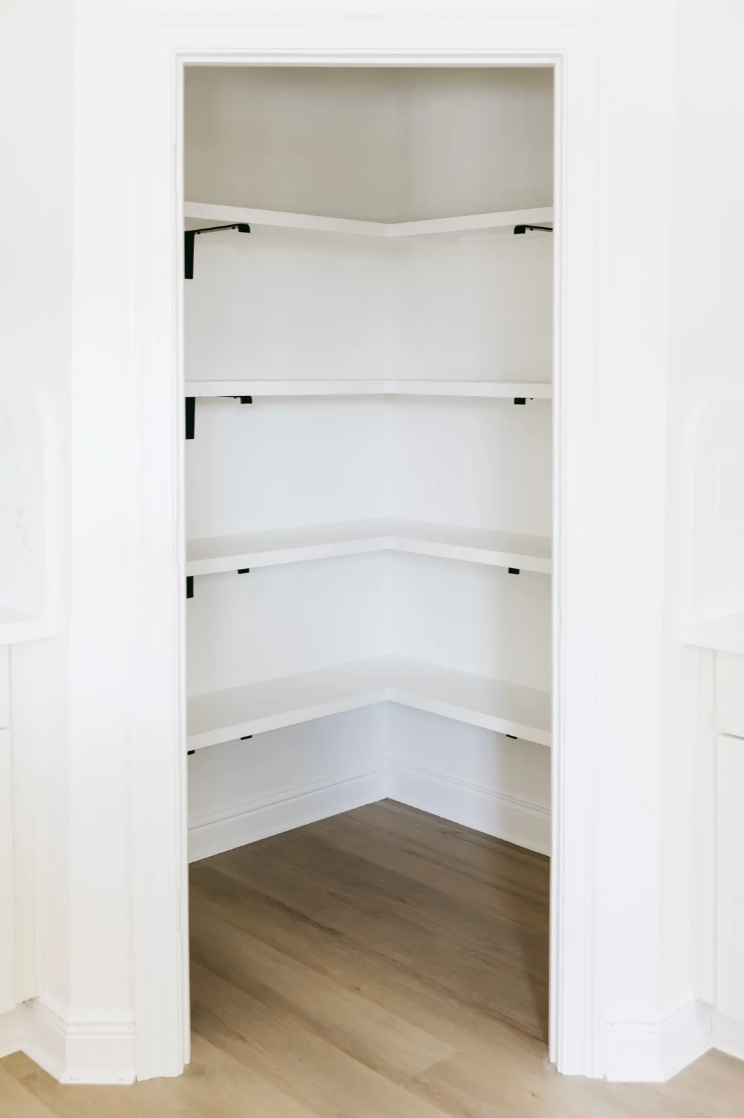 Walk-in pantry with open shelving and iron bracket supports
