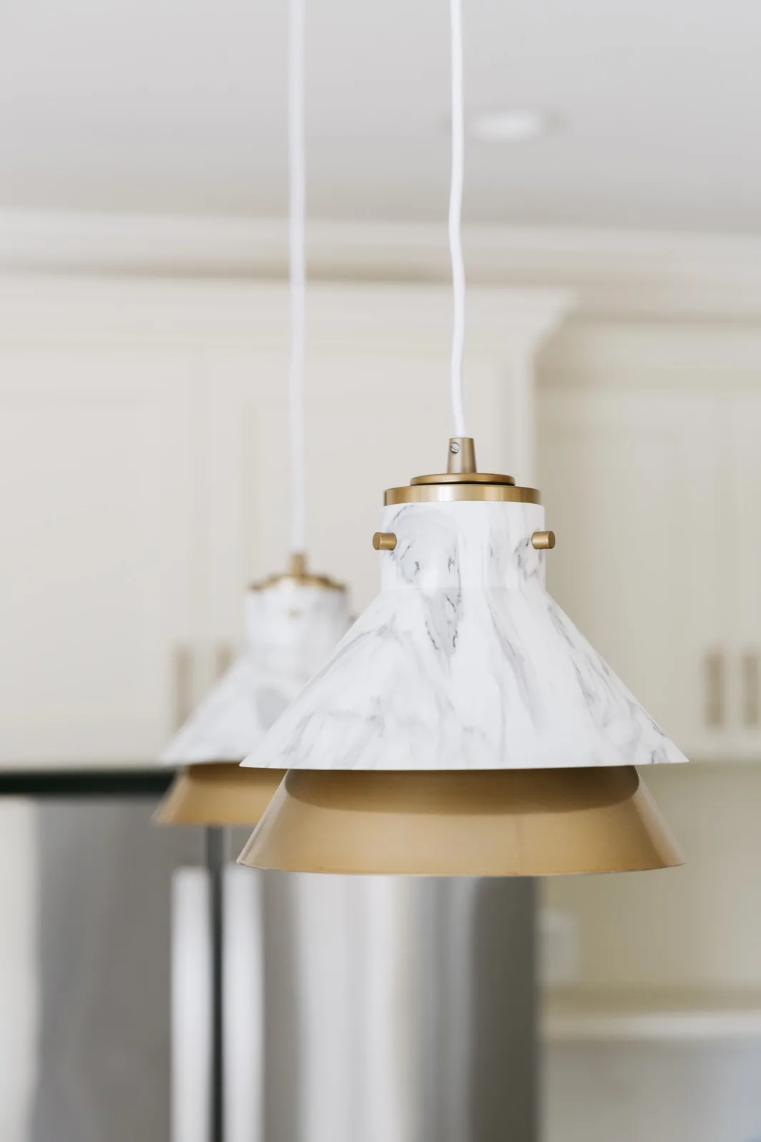 Pendant light extreme close-up — marble body with brushed brass band