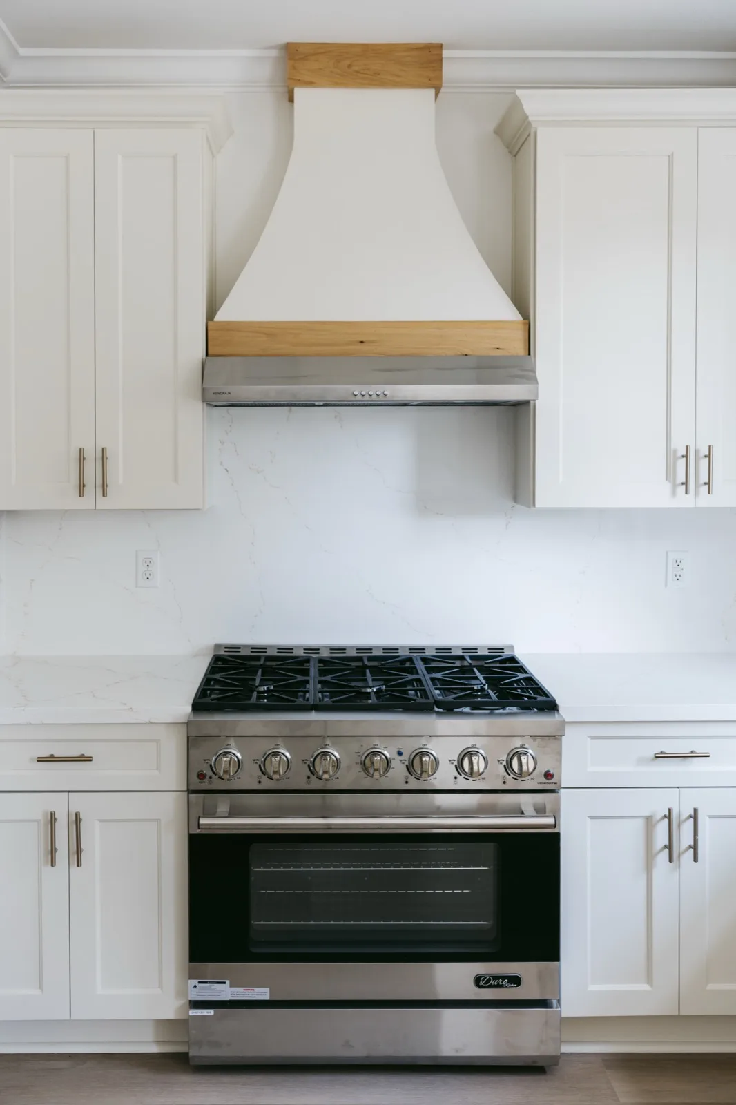 Mandeville luxury renovation — custom range hood with natural wood trim