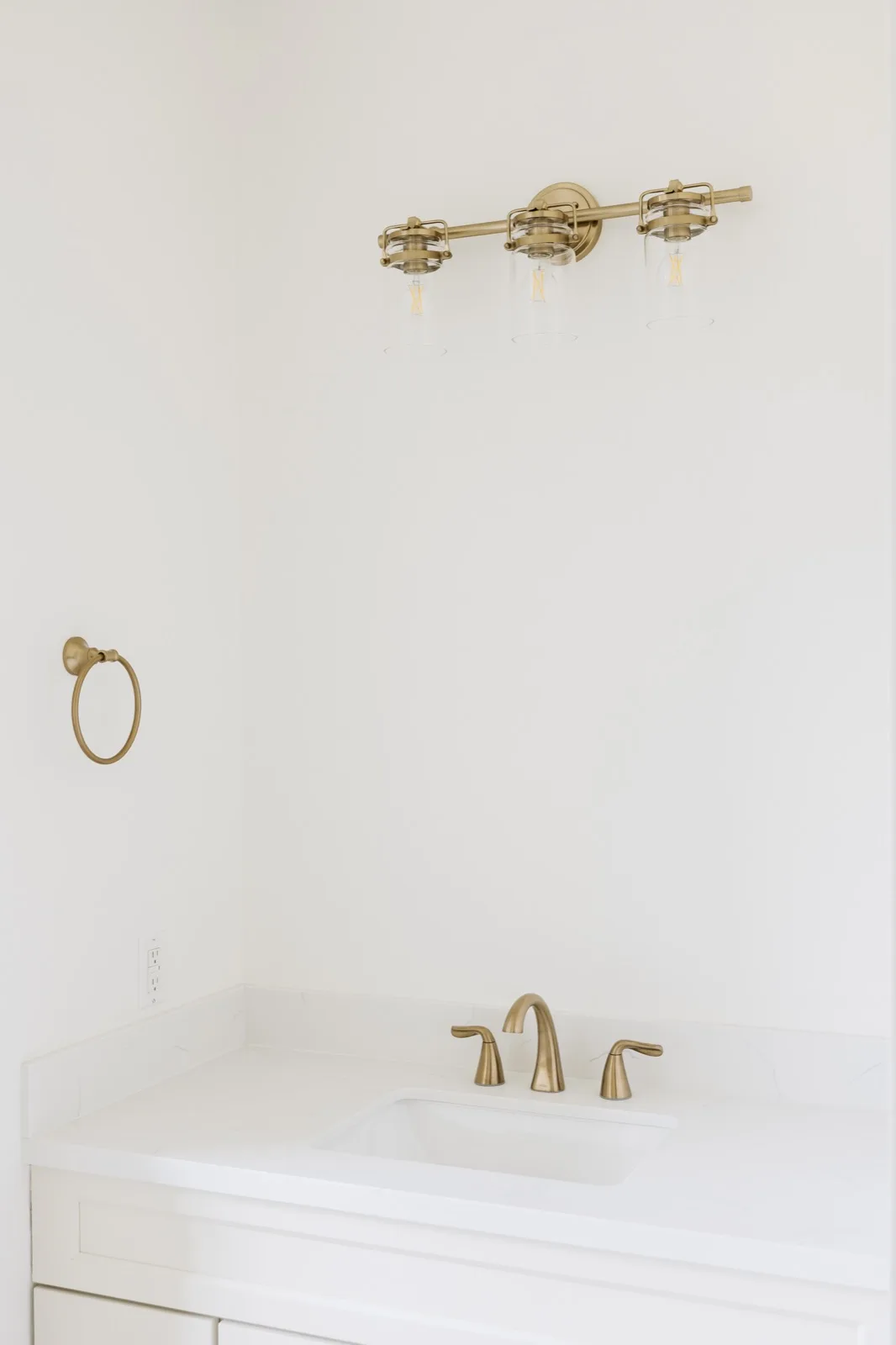 Brass shower fixtures close-up — pressure valve, rain showerhead, and glass handle