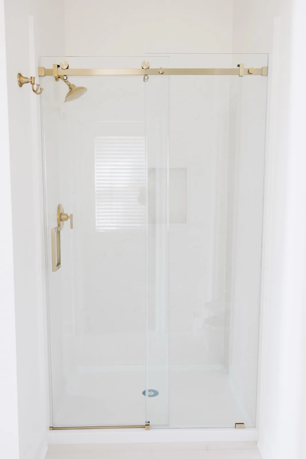 Mandeville luxury renovation — glass shower with brass barn-door hardware
