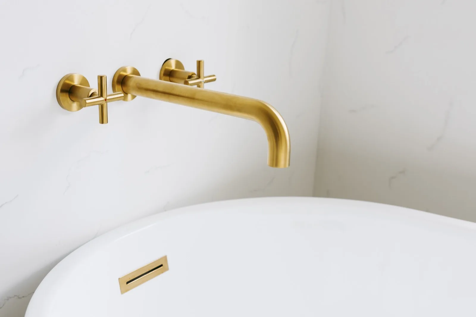 Brass cross-handle tub filler and freestanding tub rim — landscape view