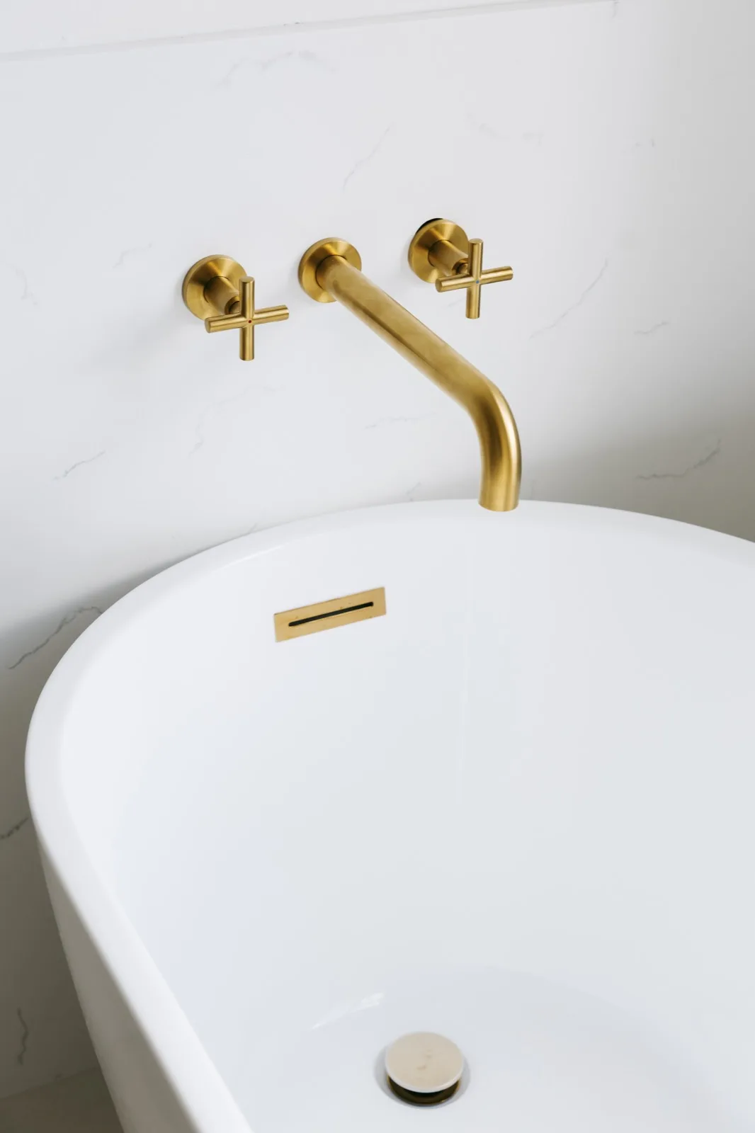 Brass tub filler from wider angle — cross handles with hot/cold indicators visible