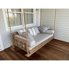 Natural wood bed swing on white porch with striped cushions and wood flooring